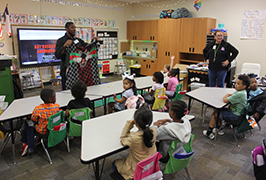  Students look at a barber holding up a cape